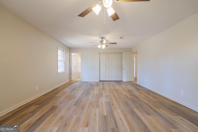 unfurnished bedroom with light wood finished floors, a closet, visible vents, and baseboards