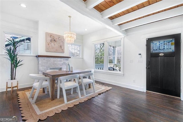 dining space featuring an inviting chandelier, baseboards, beamed ceiling, and wood finished floors