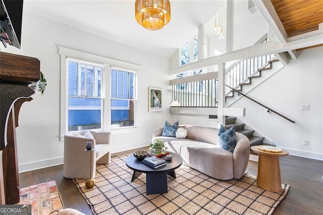 living area featuring stairs, a wealth of natural light, baseboards, and wood finished floors