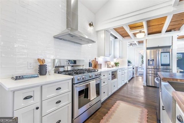 kitchen featuring dark wood finished floors, stainless steel appliances, decorative backsplash, white cabinets, and wall chimney exhaust hood