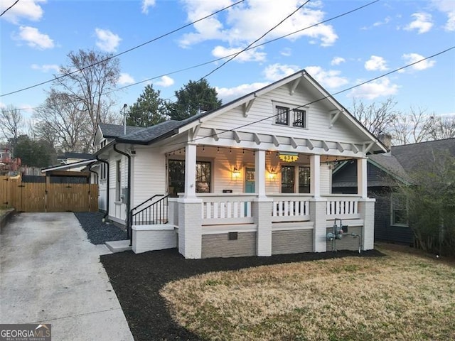 bungalow-style house featuring covered porch and a front yard