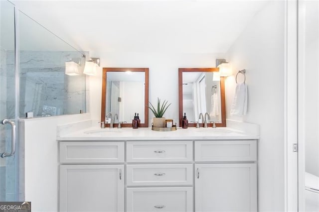 full bathroom featuring double vanity, a stall shower, and a sink