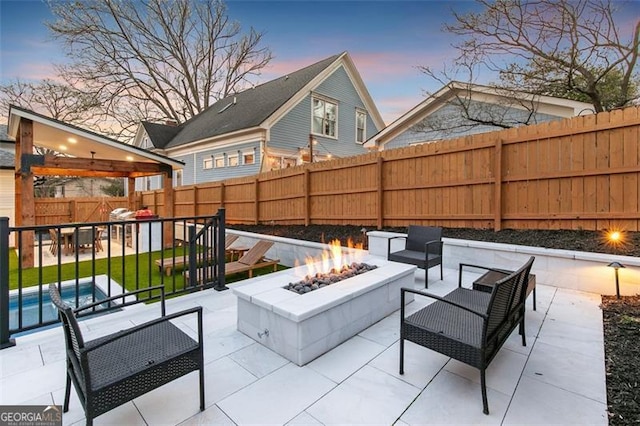 view of patio / terrace featuring a fenced backyard, a fenced in pool, and an outdoor living space with a fire pit