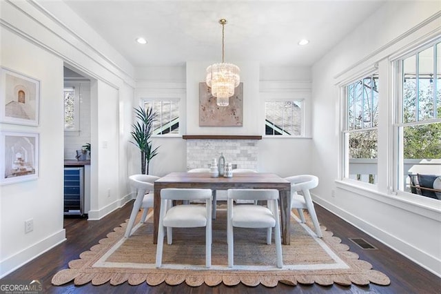 dining space featuring dark wood finished floors, recessed lighting, visible vents, an inviting chandelier, and baseboards