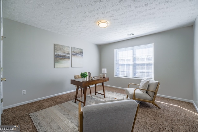 office area with visible vents, a textured ceiling, and baseboards