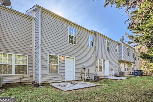 rear view of house featuring a patio area, a lawn, and central AC