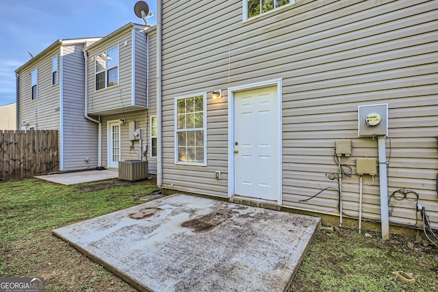 exterior space featuring central air condition unit, fence, a lawn, and a patio