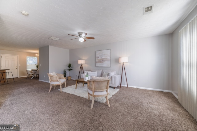 living room with visible vents, light carpet, ceiling fan, a textured ceiling, and baseboards