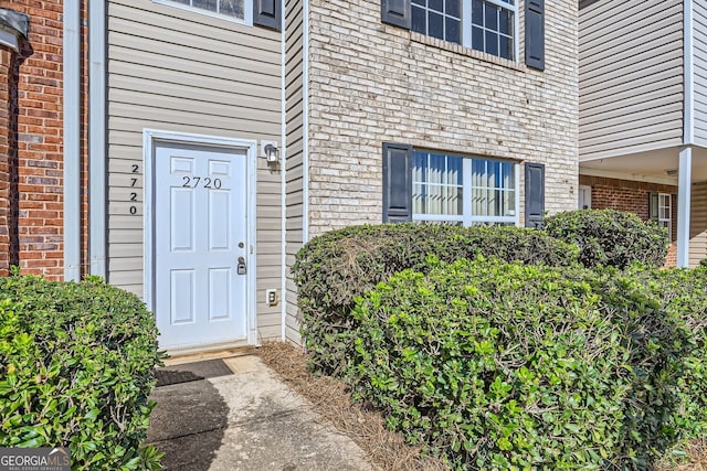 view of exterior entry featuring brick siding