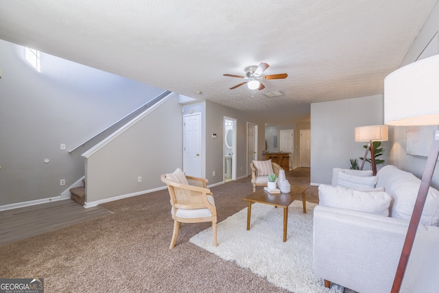 living area with visible vents, baseboards, a ceiling fan, stairs, and carpet flooring