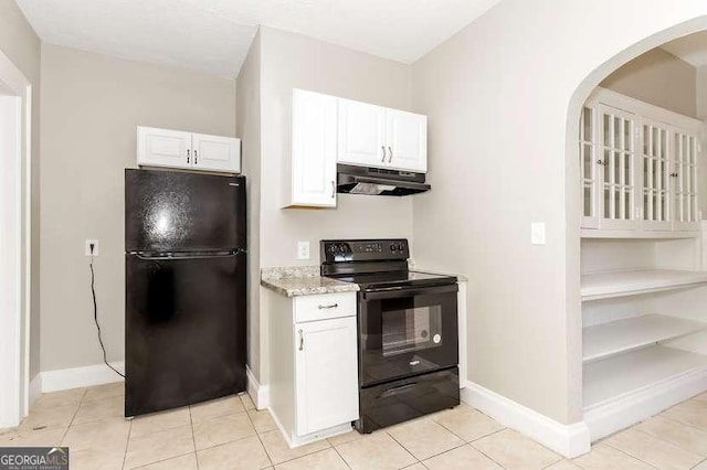 1709 Rogers Ave SW, Atlanta, GA 30310 - kitchen with baseboards, white cabinets, light stone countertops, under cabinet range hood, and black appliances