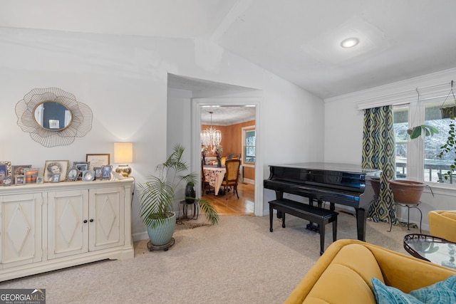 living area featuring baseboards, an inviting chandelier, carpet flooring, and vaulted ceiling