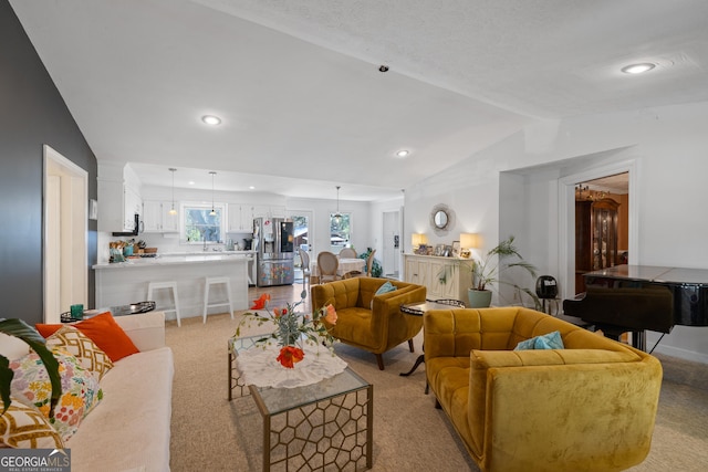 living area with vaulted ceiling, recessed lighting, and light carpet