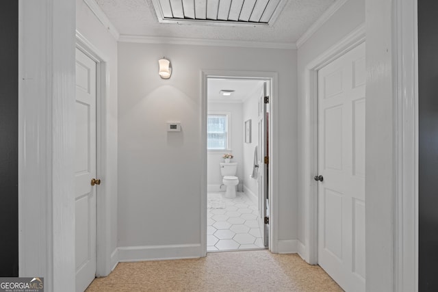 corridor featuring a textured ceiling, light carpet, baseboards, and ornamental molding