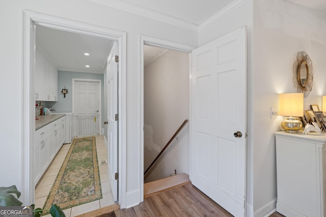 hallway with an upstairs landing, washer / clothes dryer, recessed lighting, crown molding, and light wood finished floors