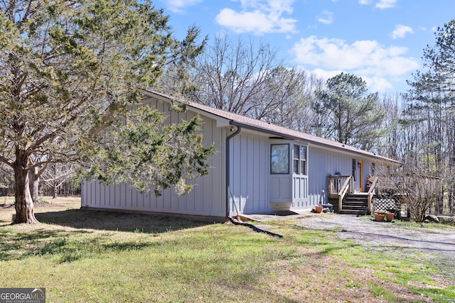 view of property exterior with a yard, board and batten siding, and a wooden deck