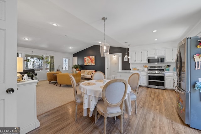 dining space featuring recessed lighting, light wood-style floors, and vaulted ceiling