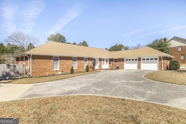 ranch-style home with an attached garage, brick siding, fence, concrete driveway, and roof with shingles