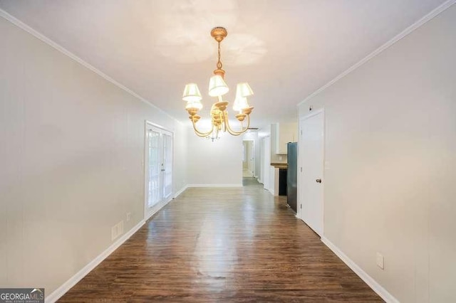 unfurnished dining area with crown molding, baseboards, dark wood finished floors, and a notable chandelier