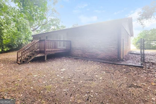 back of property with brick siding and a deck