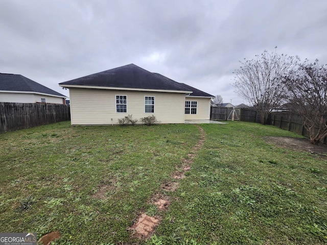 back of property featuring a fenced backyard and a yard