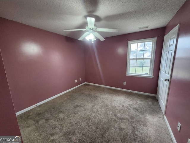 unfurnished room with a textured ceiling, a ceiling fan, visible vents, baseboards, and carpet