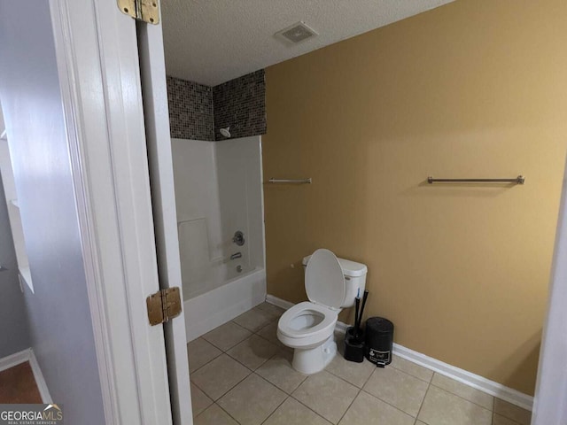 full bath featuring toilet, tub / shower combination, a textured ceiling, baseboards, and tile patterned floors