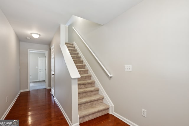 staircase featuring baseboards and wood finished floors