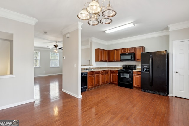 kitchen with ornamental molding, light countertops, a sink, and black appliances