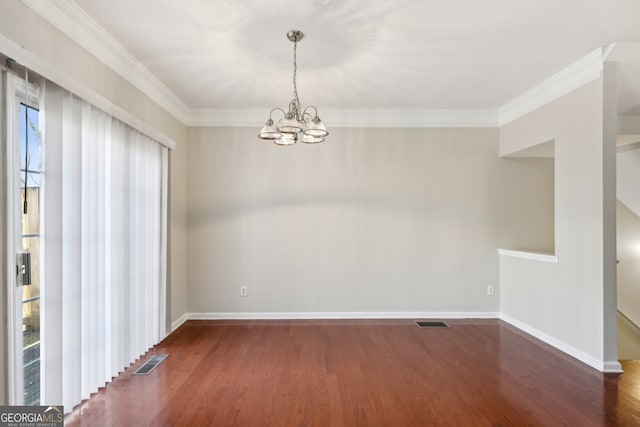 spare room featuring ornamental molding, wood finished floors, visible vents, and baseboards