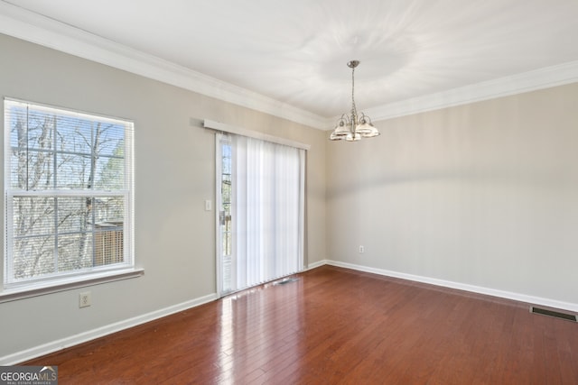 empty room with visible vents, baseboards, hardwood / wood-style floors, and ornamental molding