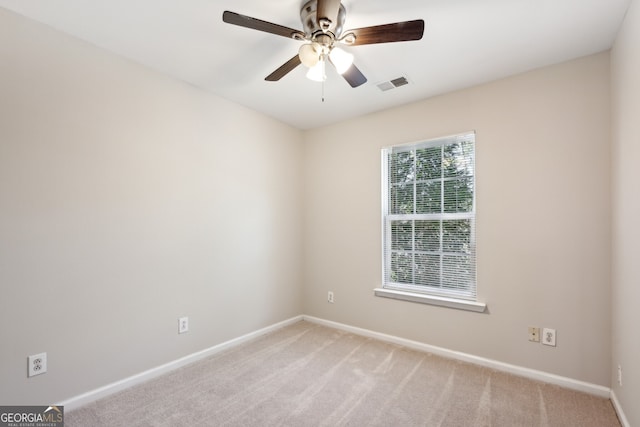 unfurnished room with visible vents, ceiling fan, light carpet, and baseboards