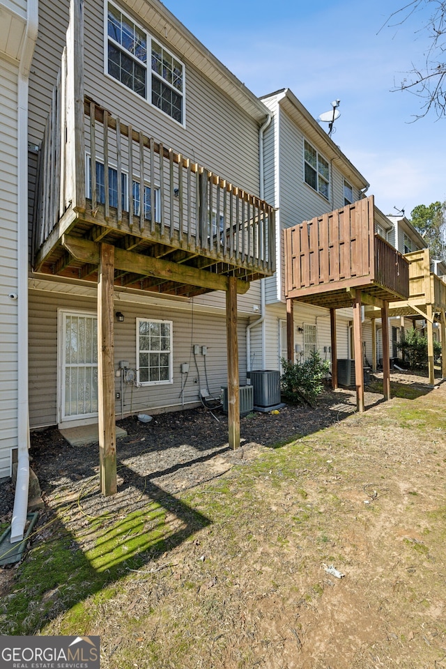 rear view of property with cooling unit and a wooden deck