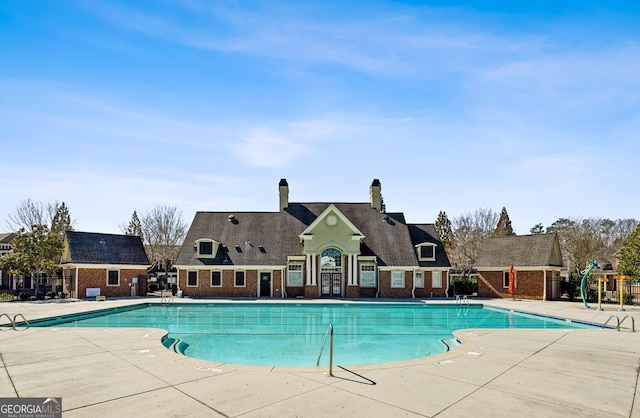 community pool featuring a patio and fence