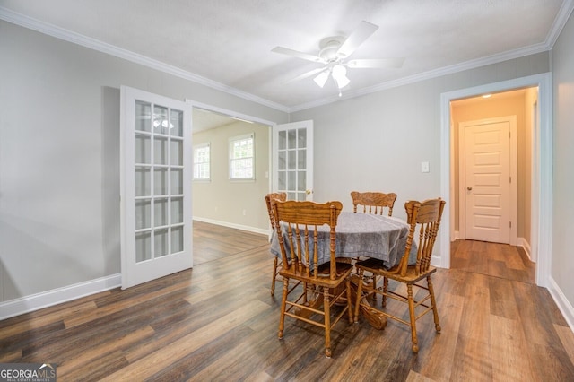 dining area featuring baseboards, ornamental molding, and wood finished floors