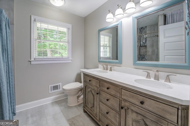 full bath with double vanity, baseboards, visible vents, and a sink