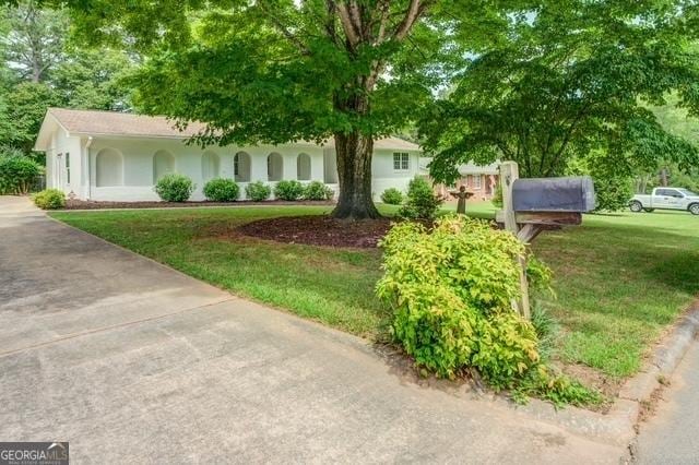 single story home featuring a front lawn and stucco siding