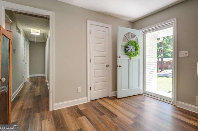 entryway featuring baseboards, visible vents, and wood finished floors