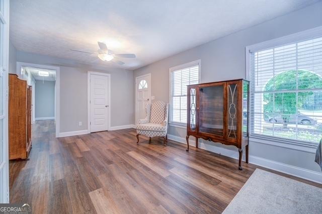 unfurnished room featuring ceiling fan, baseboards, and wood finished floors