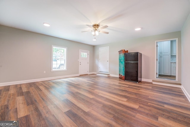 unfurnished living room featuring baseboards, dark wood finished floors, a ceiling fan, and recessed lighting