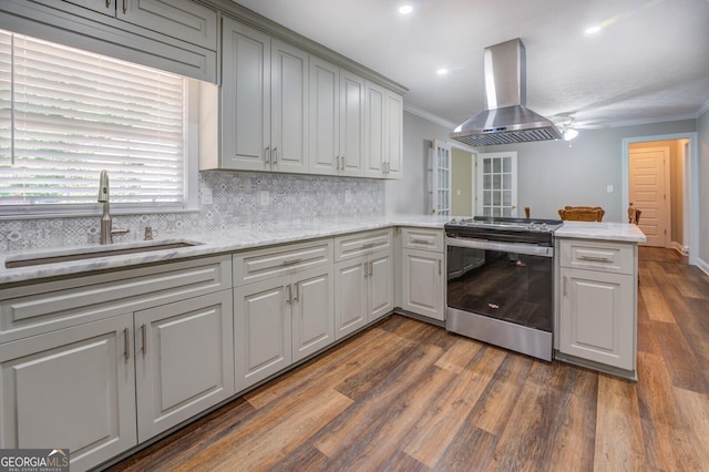 kitchen with a peninsula, a sink, ornamental molding, stainless steel electric range oven, and island exhaust hood