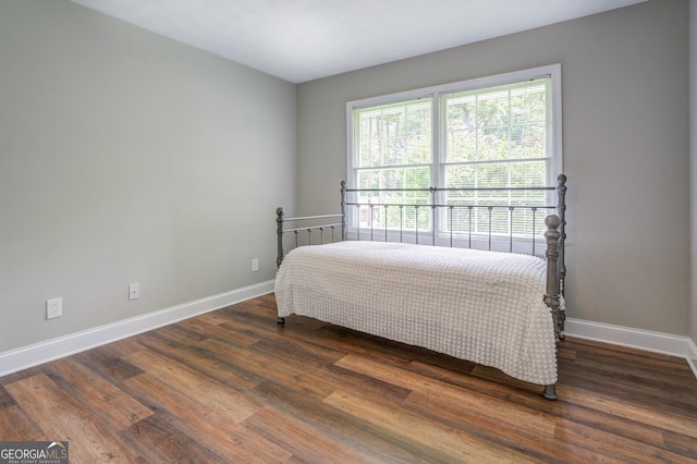 bedroom with dark wood finished floors and baseboards