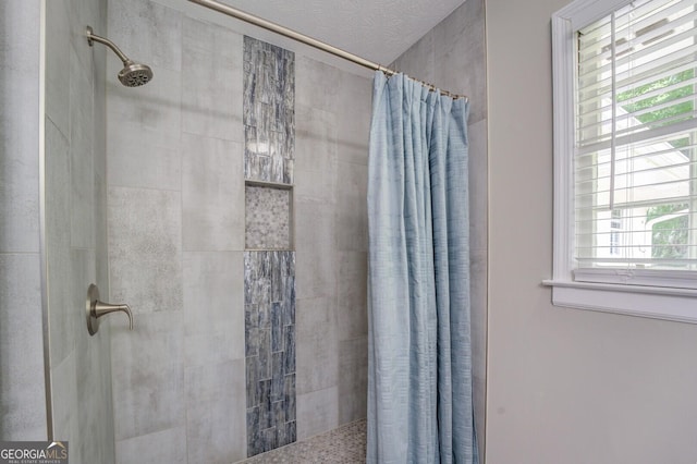 full bath with a tile shower and a textured ceiling