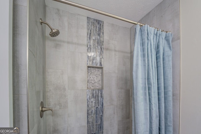 full bathroom with a textured ceiling and tiled shower