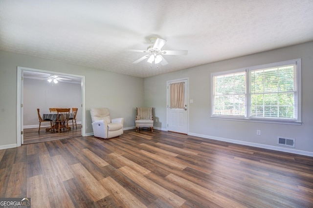 unfurnished room with a ceiling fan, baseboards, visible vents, and wood finished floors