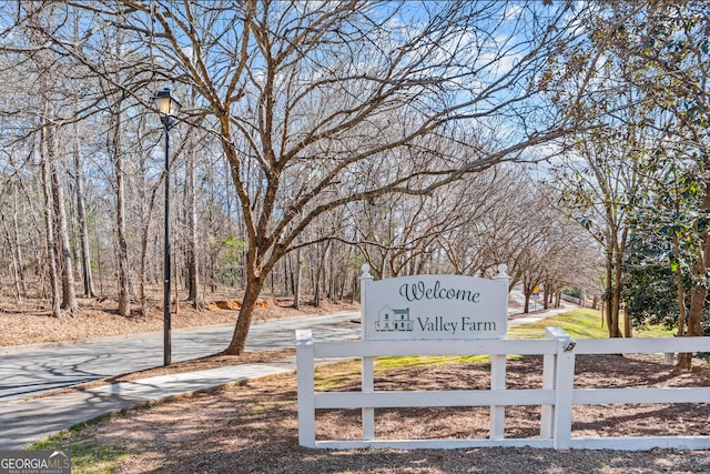 community / neighborhood sign featuring fence