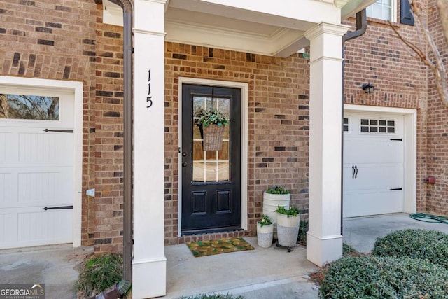 entrance to property featuring brick siding and an attached garage