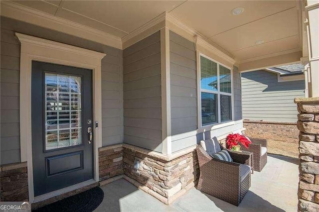 property entrance with a porch and brick siding