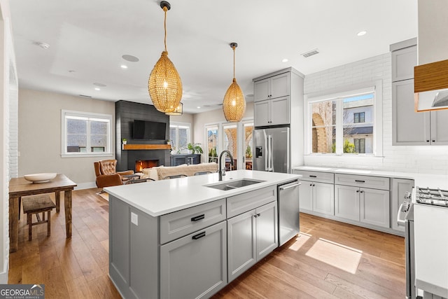 kitchen with appliances with stainless steel finishes, a sink, visible vents, and gray cabinetry