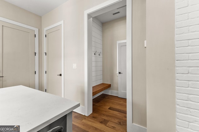 mudroom with dark wood-type flooring, visible vents, and baseboards